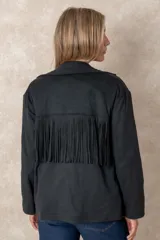 Chaqueta de gamuza sintética color marrón, con diseño de flecos en el pecho y la espalda. Presenta cierre frontal con botones, cuello camisero y bolsillos cuadrados frontales.