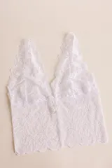 Topcito tipo bralette de encaje negro con escote en V profundo y tirantes anchos. El encaje es elastizado para un ajuste cómodo.