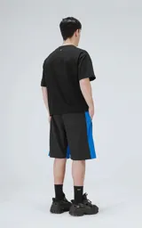 Bermuda de tela liviana de secado rápido, color negro con paneles laterales en azul eléctrico. Posee cintura elástica con cordón de ajuste estampado y bolsillos laterales y un bolsillo cargo con solapa en la pierna derecha.