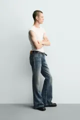 Jeans flare fit de tiro medio, confeccionados en denim de algodón color azul con efecto deslavado. Diseño ajustado en la parte superior y abierto en campana desde la rodilla, con cinco bolsillos y cierre frontal con cremallera y botón.