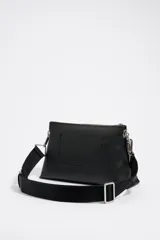 Bolso bandolera negro de tamaño mediano con textura granulada, cierre de cremallera, doble asa (una de tejido logotipada y otra de cadena metálica plateada). Incluye bolsillo interior de piel y logo metálico Chimo en el exterior.