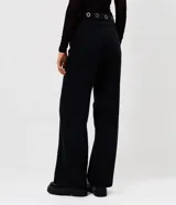Pantalón de jean corte wide leg, color negro, con cintura media y detalle de ojales metálicos en el cós. Presenta piernas amplias, cierre tradicional y bolsillos funcionales.