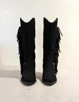 Bota de caña alta confeccionada en cuero vacuno color marrón oscuro, con diseño estilo western que incluye flecos laterales, taco cuadrado de madera y punta fina.