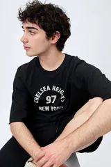 Buzo negro de corte holgado con estampado frontal que dice "Chelsea Heights 97 New York".