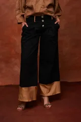 Pantalón ancho negro de tiro alto con tres botones frontales y puños anchos de color camel.