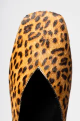 Zapato plano tipo ballerina con escote en V y punta cuadrada, confeccionado en cuero con estampado animal print de leopardo.