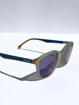 Lentes de sol Osten modelo Maui, con armazón negro de diseño redondeado y detalles en color naranja en las patillas. Cuentan con cristales polarizados con protección UV 400.