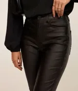 Pantalón skinny de sarga resinada color marrón, con cintura media, trabillas y bolsillos.