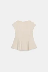 Top de piqué color beige, con cuello redondo, manga corta y bajo acabado en peplum.