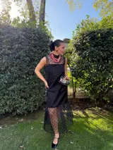 Vestido largo color ocre con estampado de cuadrados dorados, cuello alto y corte amplio. Incluye viso liso al tono.