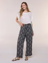 Pantalón wide leg de calce holgado y caída fluida, color negro con estampado de arabescos blancos. Cuenta con cintura elastizada fruncida con lazo ajustable, terminaciones en canutillo de madera y bolsillos laterales funcionales.