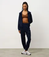 Pantalón deportivo tipo jogger color bordó, confeccionado en tejido de modal con poliéster y elastano. Presenta cintura fija, recortes estratégicos en el diseño y terminación ajustada en la botamanga.