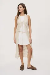 Falda corta blanca con diseño de volados escalonados y cintura elastizada, de silueta fluida y liviana.