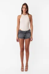 Short de jean gris oscuro, tiro medio, con ruedo desflecado, pasacintos, cierre y botón metálico. Tiene bolsillos delanteros y traseros.