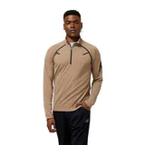 Buzo deportivo color marrón claro con cierre de cremallera corto en el cuello y detalles en negro en hombros y mangas. Logo de New Balance estampado en la manga izquierda.