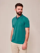 Remera polo blanca de manga corta, con detalles en azul marino en el cuello y los puños, y el logo bordado en el pecho.