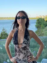 Vestido midi con estampado abstracto en tonos oscuros y claros, con escote halter profundo y diseño ajustado en el torso que se abre hacia una falda fluida.