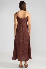 Vestido largo hasta el tobillo color marrón con estampado animal, breteles finos y escote en V profundo con detalle de flor.