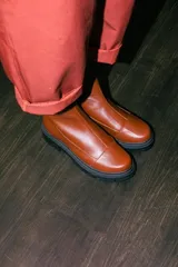 Borcegos de cuero negro con caña media, cierre lateral interno y suela track de goma con plataforma de 4,5 cm.