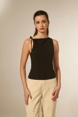 Top sin mangas de viscosa color negro, ajustado al cuerpo, con cuello redondo y frunces asimétricos en el hombro izquierdo.