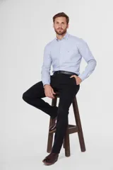 Pantalón de gabardina color negro, corte slim fit y tiro medio.