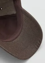 Gorra de algodón marrón con visera curva y cierre regulable metálico en la parte posterior.