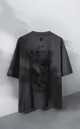Remera de manga corta con cuello redondo y calce oversize, color gris oscuro. Presenta una estampa frontal con diseño gráfico de un escorpión y una rosa, junto con texto tipográfico.