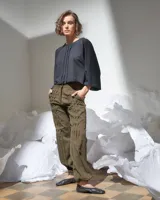 Pantalón verde militar tornasolado de algodón brillante, corte a la cintura y piernas rectas con textura de tableado central.