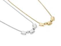 Collar de acero plateado con cadena de eslabones y cinco dijes: tres barras rectangulares y dos esferas.