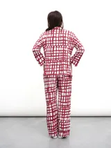 Conjunto de pijama de dos piezas, color verde menta con estampado de cuadros irregulares en blanco. Incluye camisa de manga larga con botones y pantalón largo con cintura elástica.