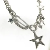 Collar plateado con cadena de eslabones gruesos y dijes colgantes de estrellas de diferentes tamaños y diseños, incluyendo una estrella con contorno, una estrella rellena, una estrella con cristales y una estrella de cinco puntas.