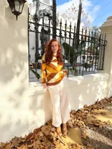 Sweater de punto con diseño geométrico en tonos mostaza, marrón y beige.