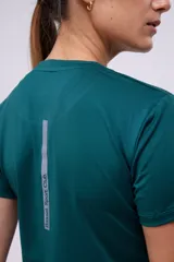 Remera deportiva verde esmeralda con tecnología dryfit y logo estampado en el frente.