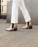 Botines Chelsea color beige con apliques marrones en los laterales y el talón, con elástico negro en los laterales y tacón bajo.