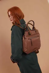 Cartera mochila de diseño versátil, color rosado, confeccionada en material sintético impermeable. Cuenta con doble asa superior, correas ajustables para usar como mochila, compartimento principal con cierre y bolsillo frontal con cierre decorado con tirador largo.