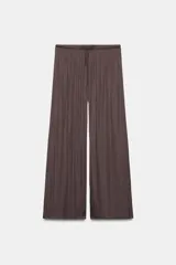 Pantalón de tiro medio, color negro, confeccionado en tejido satinado con diseño de pierna ancha y cintura elástica ajustable con cordón.