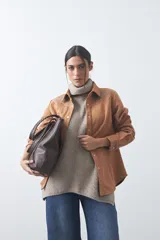 Sobrecamisa de gamuza color marrón con bordados decorativos estilo western en la zona de los hombros y cierre frontal con botones metálicos.