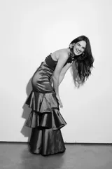 Falda larga marrón de tafeta con tajo lateral y volados en el ruedo.