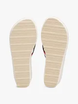 Sandalias tipo ojota con plataforma de cuña alta, color beige claro. Las tiras son de tejido trenzado con las franjas distintivas de Tommy Hilfiger (azul marino, blanco y rojo).