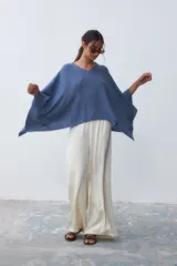 Poncho tejido de punto color azul con cuello en V y mangas amplias.