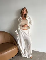 Pantalón de viscosa color beige claro, de corte amplio y pierna ancha, con cintura elástica y bolsillos laterales.