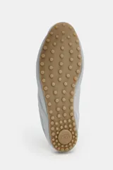 Zapato deportivo destalonado de tejido gris claro, con cordones y suela engomada con relieve de color caramelo.