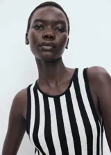 Vestido largo de punto fino con diseño evasé, cuello caja y tirantes anchos. Presenta un estampado de rayas verticales en blanco y negro y un bajo asimétrico.