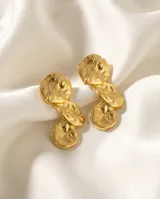 Par de caravanas de acero con baño de oro, con diseño orgánico de formas circulares y texturizadas unidas entre sí.