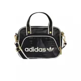 Bolso tipo bandolera Adidas Airliner, color negro con estampado geométrico sutil. Presenta el logo de la marca en el frente, detalles en blanco en los bordes y herrajes metálicos dorados. Incluye doble asa de mano y correa ajustable extraíble.