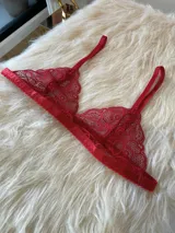 Bralette de encaje rojo con diseño triangular, breteles regulables y terminaciones con borde festoneado.