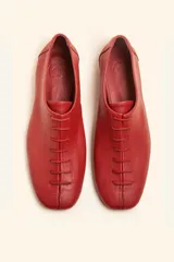 Zapatos chatos de cuero color bordó, con cordones finos y punta cuadrada.