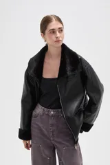 Campera de cuero sintético con interior y detalles de piel sintética en cuello, puños y ruedo. Presenta cierre frontal completo y diseño de corte holgado.