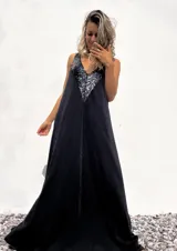 Vestido largo de corte holgado en color negro, con escote en V profundo decorado con lentejuelas negras brillantes. Presenta un diseño sin mangas y una caída fluida.