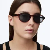 Lentes de sol con montura redonda de diseño retro, con armazón estampado en carey y cristales polarizados en color negro.
